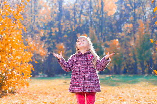 istock Girl, garden, autumn, falling leaves 1137763059