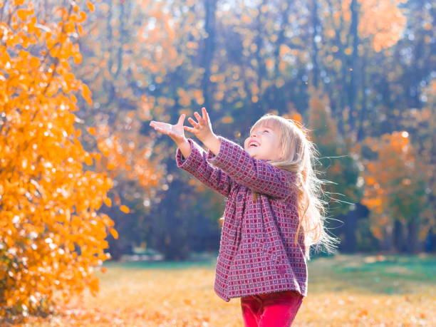 istock Girl, garden, autumn, falling leaves 1137763080