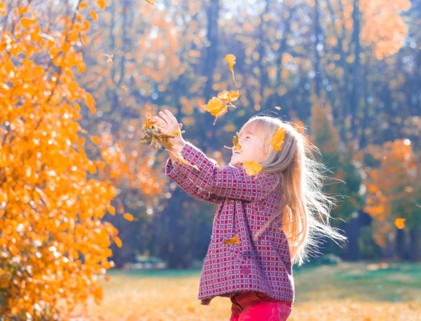 istock Girl, garden, autumn, falling leaves 1137763092