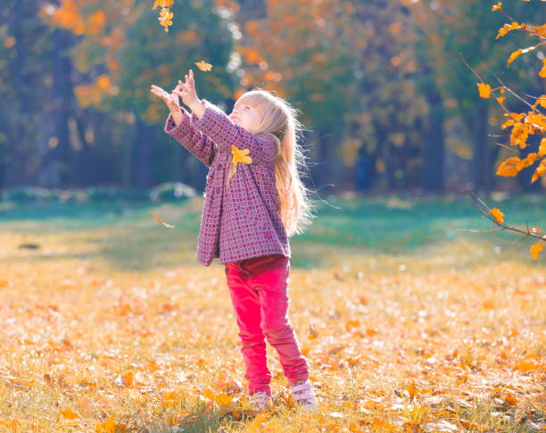 istock Girl, garden, autumn, falling leaves 1137763126