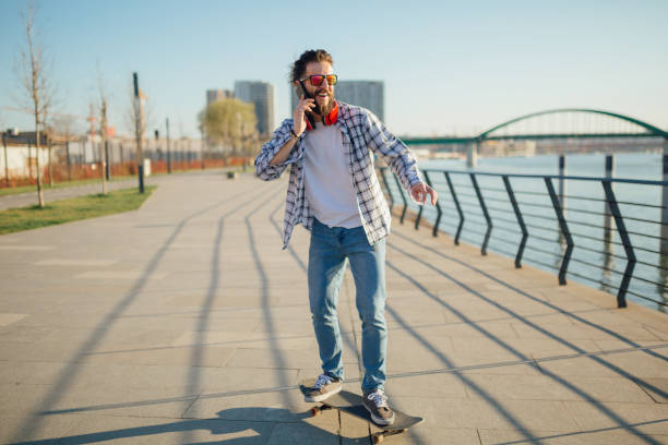 istock Man skateboarding next to the river with phone 1137763146
