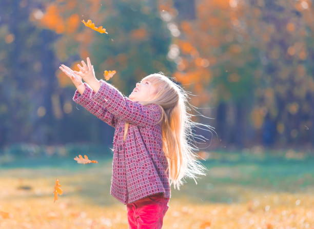 istock Girl, garden, autumn, falling leaves 1137763166