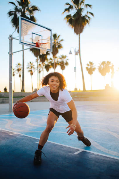 молодая женщина практикует баскетбол капать в венеции, калифорния - athlete muscular build basketball vertical стоковые фото и изображения