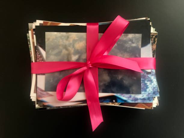 istock Messy Stack of Old Color Photos with Pink Bow 1137767001