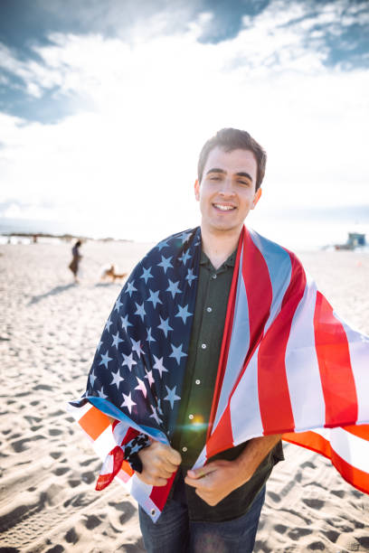 istock man with us national flag on the beach 1137770760