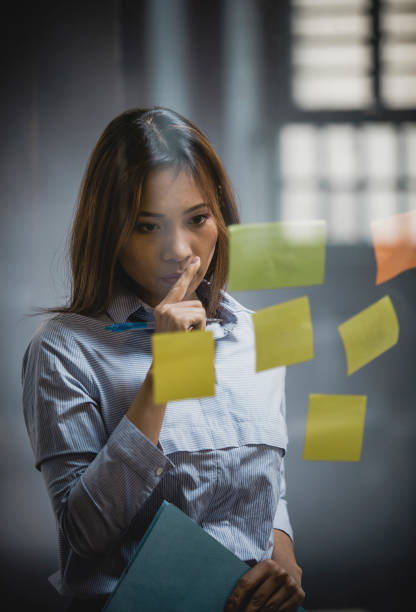 istock Businesswoman Sticking Post-it Notes to Glass 1137772339