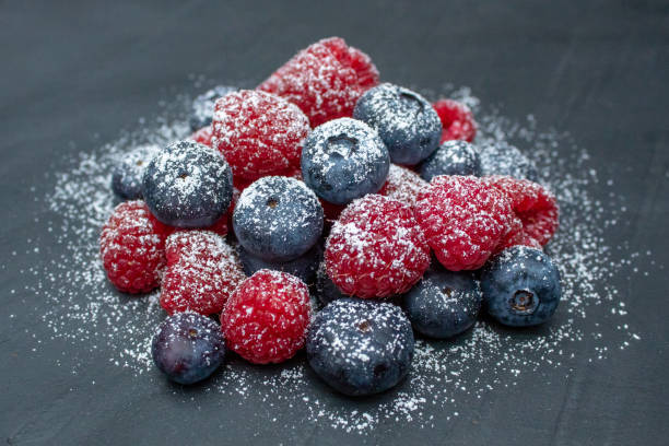 Close up overhead view of Fruit, Strawberries, Grapes, Blueberries and Raspberries with double cream poured over the top.
