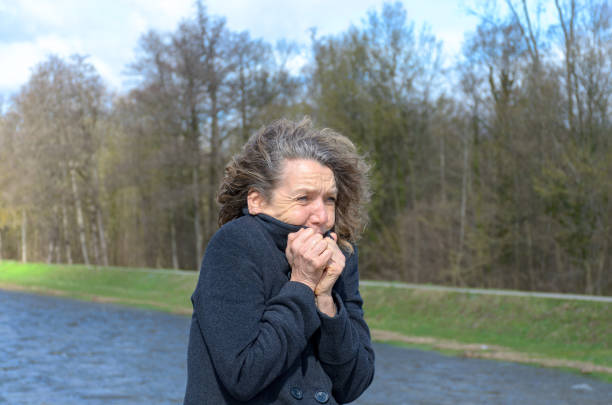 Woman snuggling into her jacket on a cold day