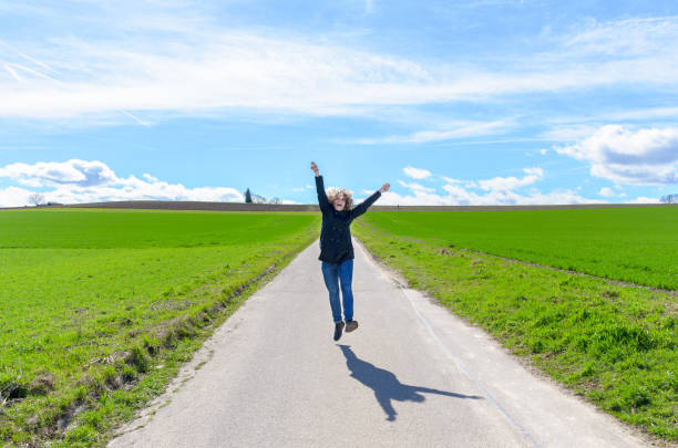 istock Joyful woman jumping in the air celebrating 1137774571