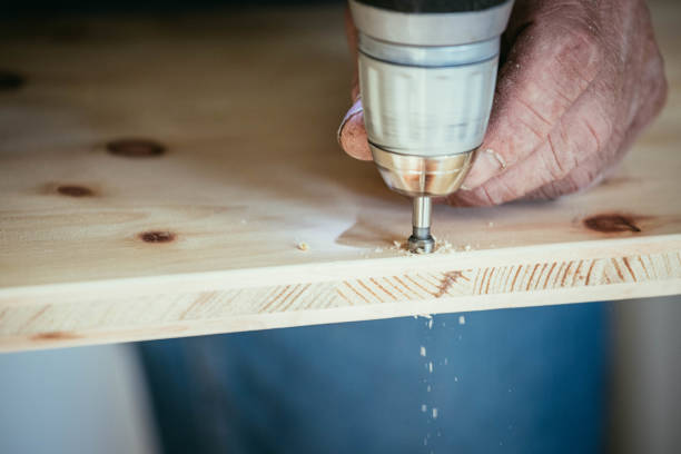 istock Craftsman is drilling in wood with drilling machine 1137776764