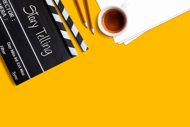 映画クラッパーボードと黄色の背景にコーヒーカップにテキストタイトルを伝える物語 - 原稿 ストックフォトと画像