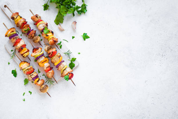 Chicken and Vegetables Skewers Grilled Chicken and Vegetable Skewers with  bell peppers, zucchini, onion and mushrooms on white background, top view, copy space. Meat and vegetables kebabs on skewers. skewer photos stock pictures, royalty-free photos & images