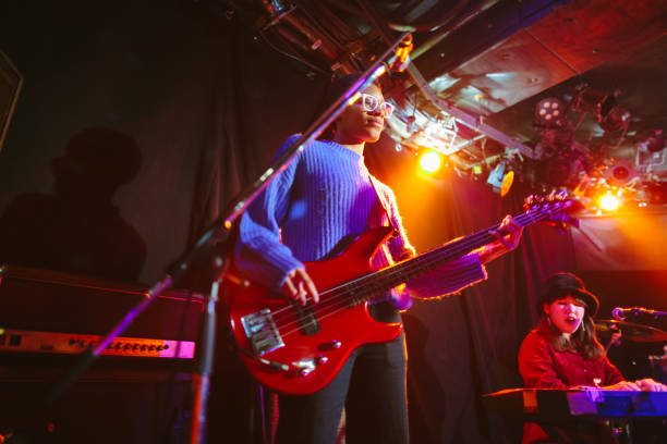 chitarrista femminile nera che suona il basso sul palco - band name immagine foto e immagini stock