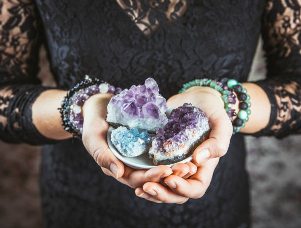 mulher do healer que prende clusters de cristal diferentes (ametista, celestite) nas mãos das palmas. feche acima da vista, usando o trabalho com conceito dos cristais. - semi precious gem - fotografias e filmes do acervo