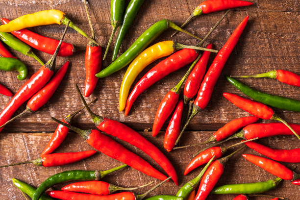 istock Flat lay red , green and yellow chili peppers pattern over wooden background. 1137783593