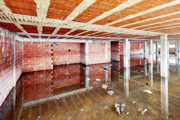 The basement of a building under construction is filled with dirty flood water The basement of a building under construction is filled with dirty flood water basement stock pictures, royalty-free photos & images