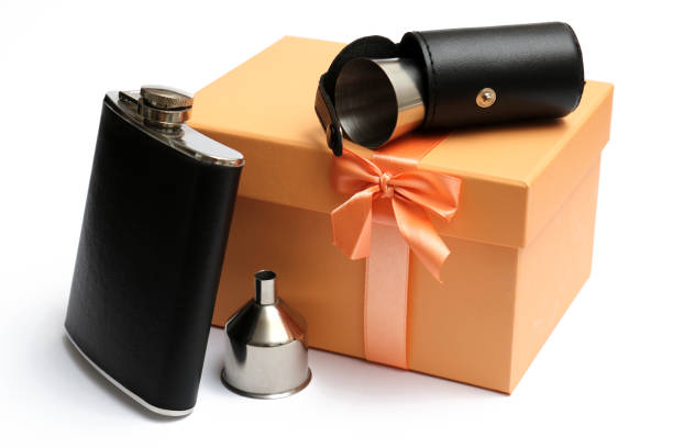 small leather hip flask with metal mug in cover at orange giftbox