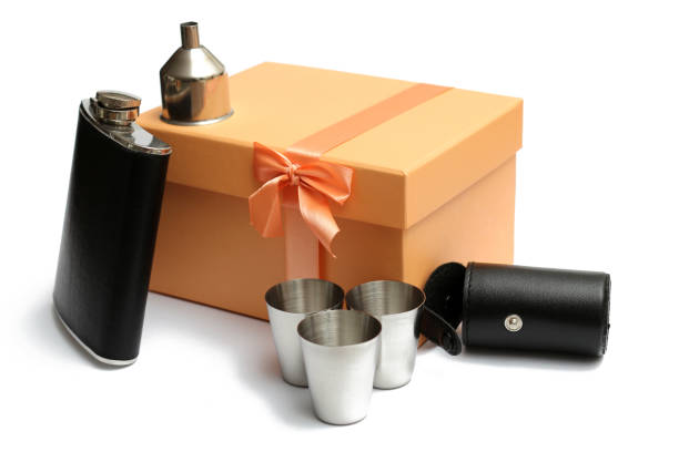 small leather hip flask with three metal mugs at orange giftbox