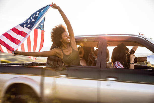 Young and fresh group of friends enjoying a road trip journey and freedom in a country road Young and fresh group of friends enjoying a road trip journey and freedom in a country road.
Note for inspectors: The car is old and edited and it was already accepted in a previous batch with no issues. patriotic man stock pictures, royalty-free photos & images