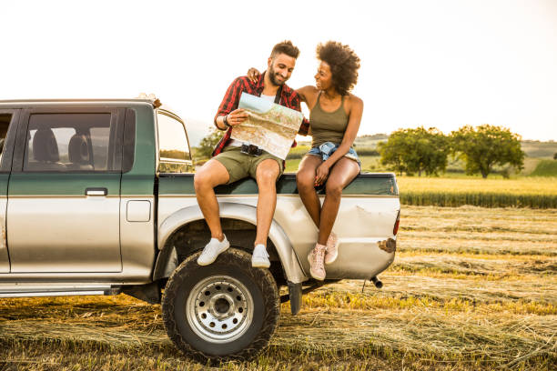 istock Young couple sitting in the car reading a road map 1137791991