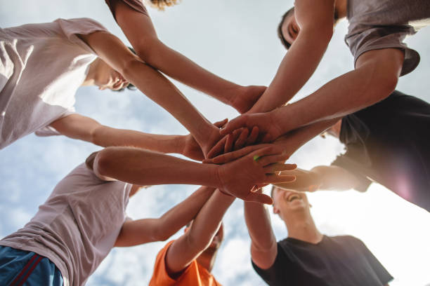 istock Cheerful group of people holding hands as a team 1137796092
