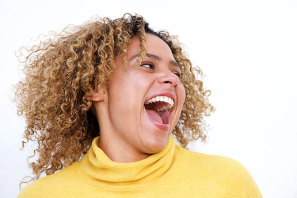 Close up happy young african american woman laughing against isolated white background Close up portrait of happy young african american woman laughing against isolated white background plus size woman fashion laughing stock pictures, royalty-free photos & images