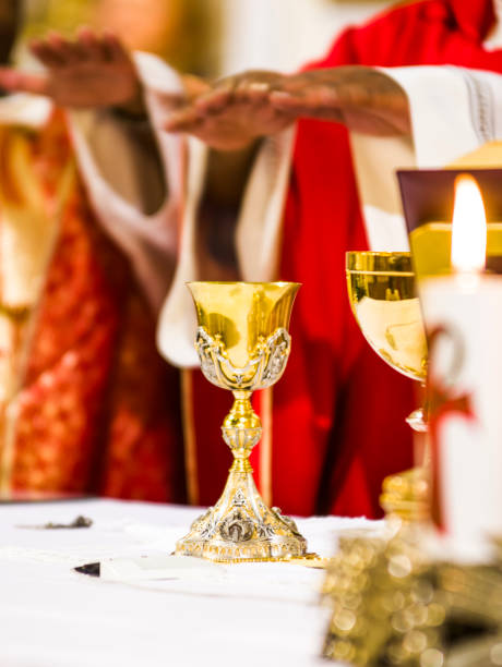 hands of the priest consecrate wine and bread on the altar of holy mass - bergoglio imagens e fotografias de stock