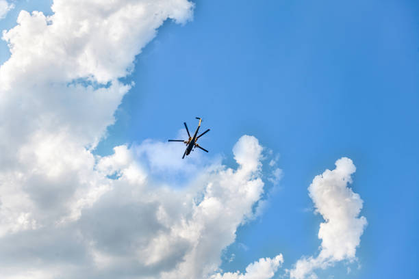 istock Helicopter flies in the blue sky with with clouds. 1137797495