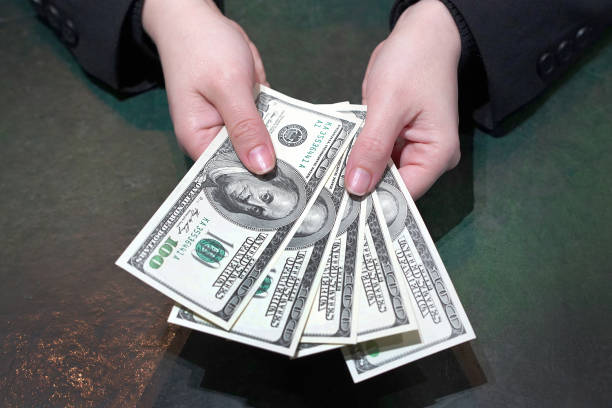 istock Woman hands hold and counting dollar banknotes 1137798350