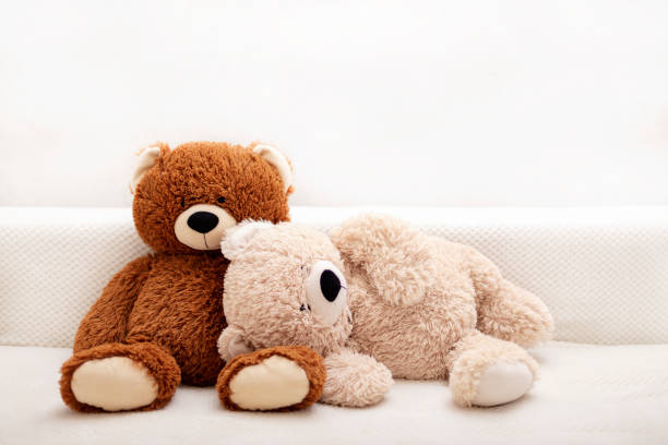 zabawki dla dzieci - niedźwiedzie w kolorze brązowym i beżowym siedzą na kanapie. - behavior teddy bear doll old zdjęcia i obrazy z banku zdjęć