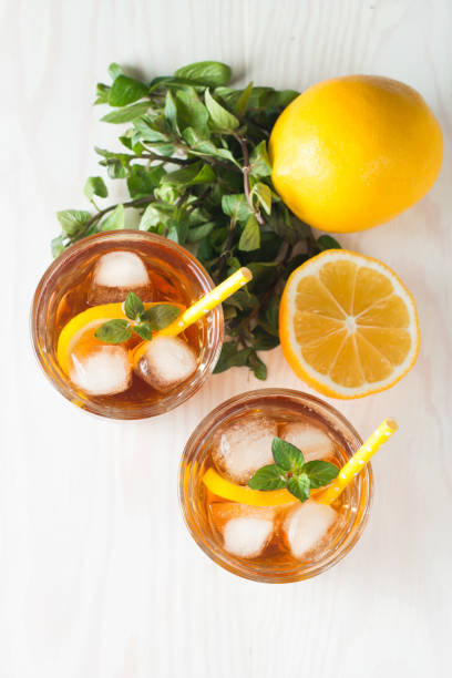 istock Refreshing citrus lemonade, summer drink. Ice tea with fresh lemon and mint on wooden background. Refreshment beverage concept. 1137802372