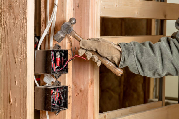 istock Handy man uses a hammer to install electrical boxes in a new home 1137804697