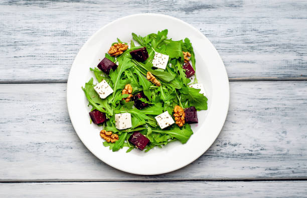 istock Salad of arugula, cheese, beet, walnut, on a wooden table 1137804792
