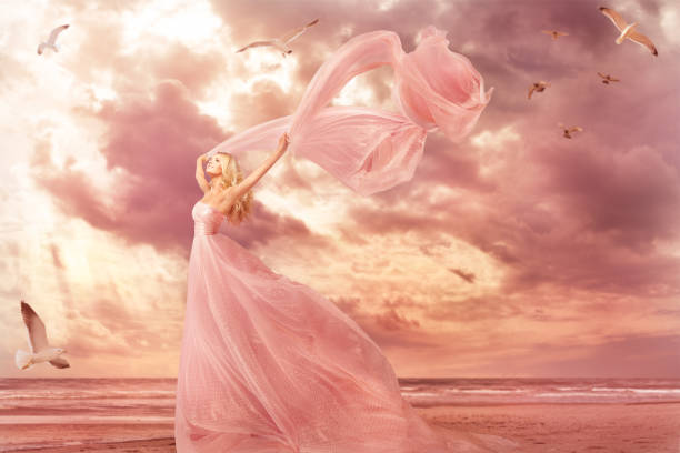 Woman Portrait in Long Dress on Sea Coast, Fantasy Girl Pink Gown with Flying Shawl in Storm Wind Woman Portrait in Long Dress on Sea Coast, Fantasy Girl Pink Gown with Flying Shawl in Storm Wind over nature sky background pink gown stock pictures, royalty-free photos & images