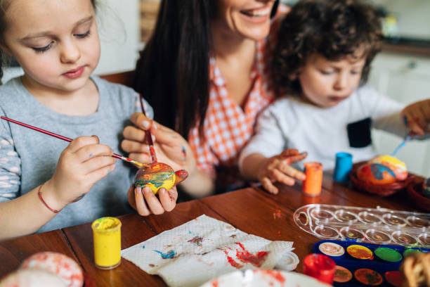 istock Mother painting Easter eggs with her children 1137814889