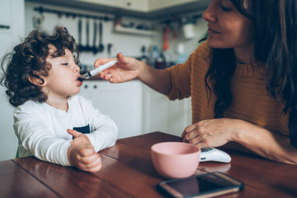 istock Mother giving syrup to her son 1137814905