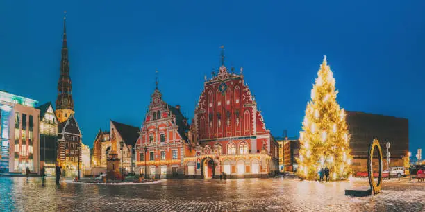 Photo of Riga, Latvia. Panorama Of Town Hall Square, Popular Place With Famous Landmarks On It In Night Illumination In Winter Twilight. Winter New Year Christmas Holiday Season