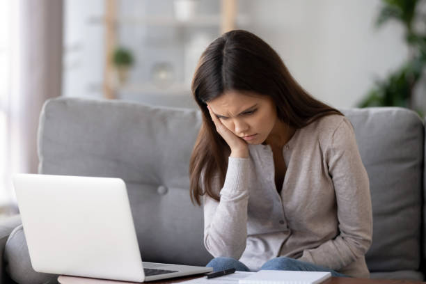 istock Bored unmotivated woman sitting at table with laptop and documents 1137821420