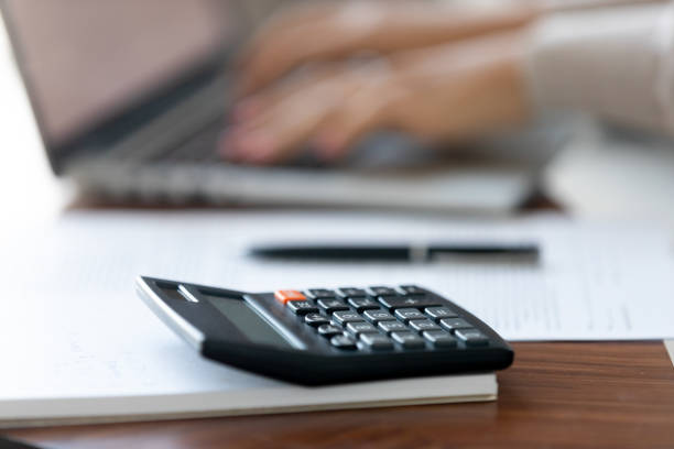 istock Close up office calculator on table, female hands typing on laptop 1137821421