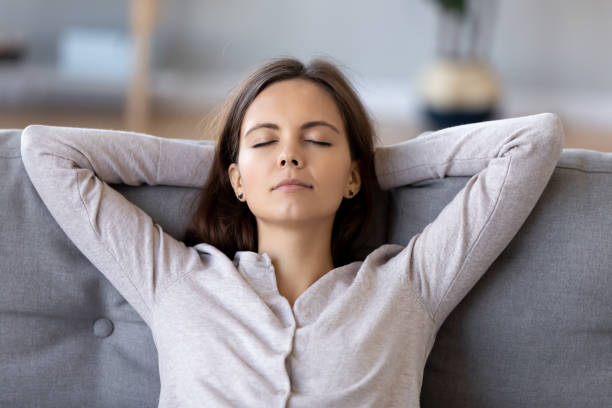 istock Peaceful young woman with hands behind head relaxing at home 1137821437