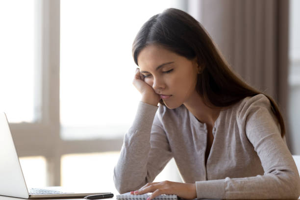 istock Exhausted woman with closed eyes sitting half asleep at workplace 1137821442