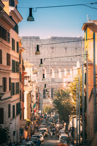 рим, италия. колизей также известен как флавиевский амфитеатр. трафик в риме возле знаменитой мировой достопримечательности - flavian amphitheater фотографии стоковые фото и изображения