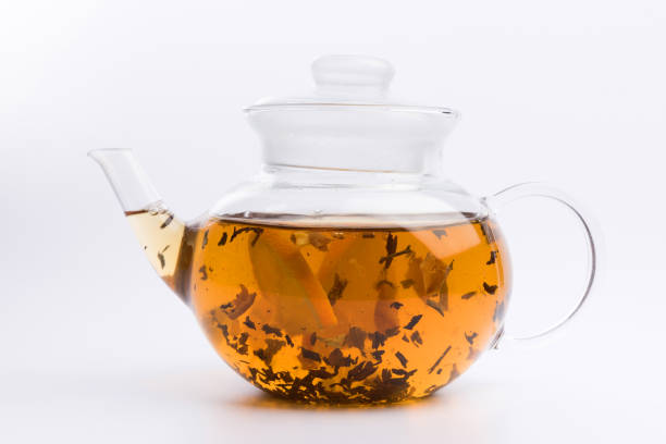 istock Glass teapot with black tea nad fresh orange isolated on white background 1137832369