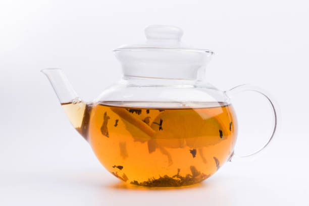 istock Glass teapot with black tea nad fresh orange isolated on white background 1137832372