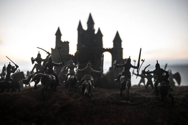 istock Medieval battle scene with cavalry and infantry. Silhouettes of figures as separate objects, fight between warriors on sunset foggy background. 1137837498