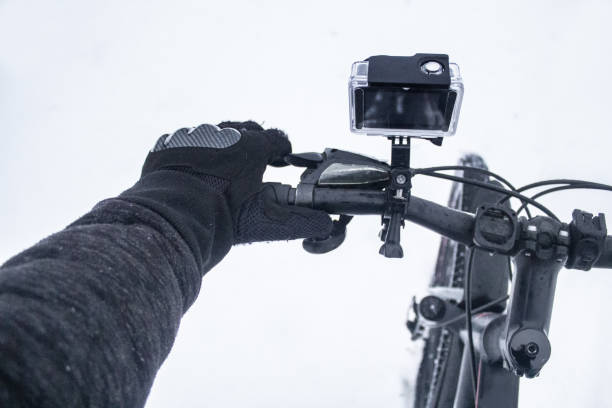 istock Action camera on a bicycle in a protective case. The guy in gloves rides a bicycle in the winter on a snow. 1137837654