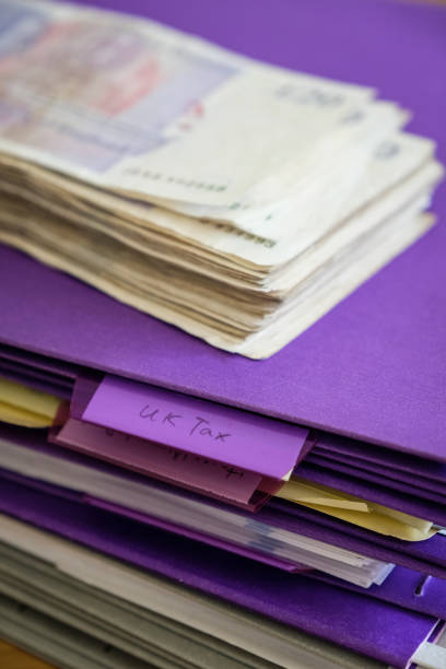 istock UK tax time, stack of twenty pound notes on tax document 1137838633