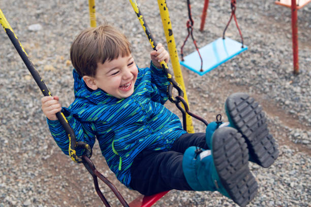 istock Happy little boy on swing in park 1137840767
