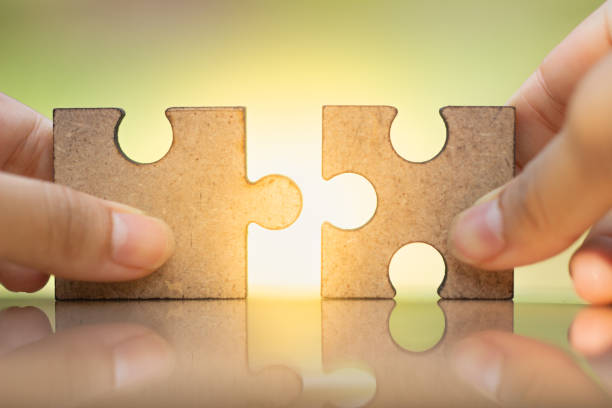 istock Woman\'s hand holding and connecting jigsaw puzzles. 1137843531
