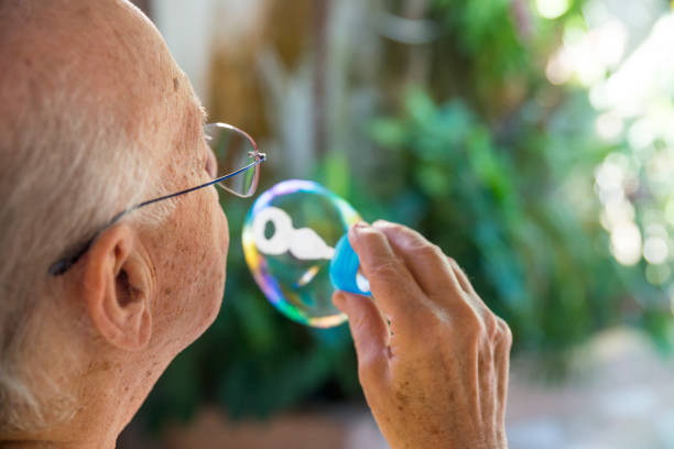 istock Senior man blowing soap bubble sud 1137844243